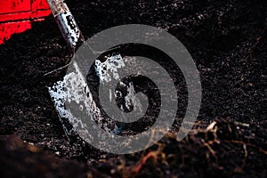 Shovel in a pile of peat soil.