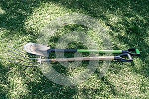 Shovel and pitchfork on green grass