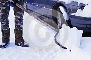 Shovel snow removal. Cleaning the car from snow in winter. Snow-covered car after a snowfall. Deteriorating weather conditions in