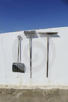 Shovel, snowy shovel, broom and water renderer hang on a  wall
