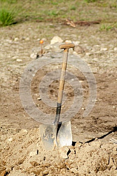 shovel stuck in a pile of earth in an archaeological dig