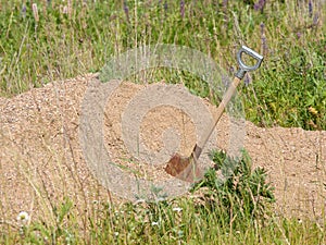 Shovel stuck in pile of sand.