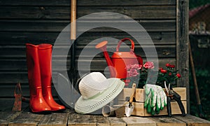 Shovel, watering can, hat, rubber boots, box of flowers, gloves and garden tools