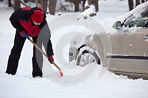 Shoveling snow from car, man shoveling snow