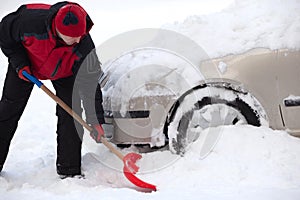 Shoveling snow from car, man shoveling snow