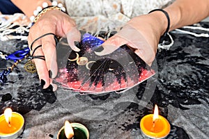 Show fortune tellers of hands holding tarot cards and tarot reader with candle light on the table, Performing readings magical