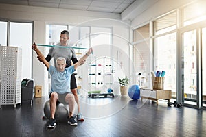 Show me how much determination you have. a young male physiotherapist assisting a senior patient in recovery.