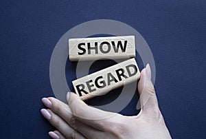 Show regard symbol. Wooden blocks with words Show regard. Beautiful deep blue background. Businessman hand. Business and Show