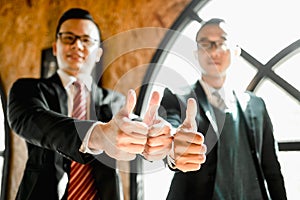 Show thumb up their hand to demonstrating their agreement to sign agreement or contract between their firms companies