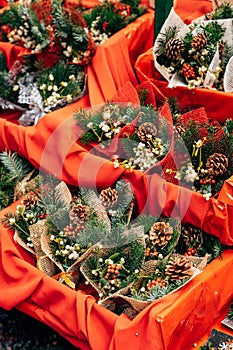 Showcase of bunch of holly the Christmas market. Envelopes with christmas tree branch, bump, berries, stars. New Year`s