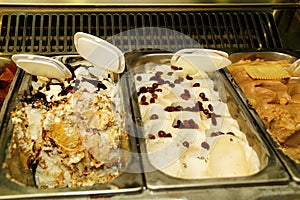 Showcase with colorful fruit ice cream. Ice cream serving counter with many scoopable flavors.