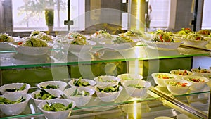 Showcase with different freshly prepared vegetable salads in self-service cafeteria or buffet restaurant. health food