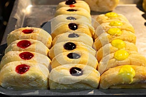 A showcase with pastries, rolls with colored fillers