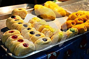A showcase with pastries, rolls with colored fillers