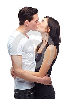 Showcasing true love. A happy young couple hugging and kissing each other while isolated on white.