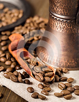 Showel with coffee beans and turkish coffee brewing pot