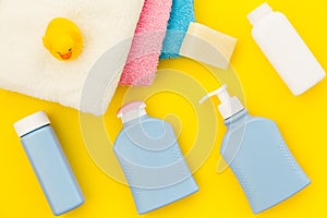Shower accessories for child. Set with shampoo, towel, soap, gel, towel, brush and yellow rubber duck on yellow