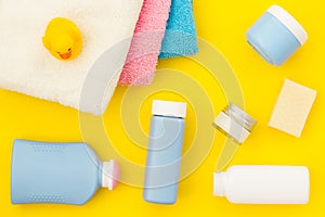 Shower accessories for child. Set with shampoo, towel, soap, gel, towel, brush and yellow rubber duck on yellow