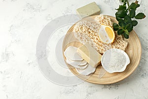 Shower accessories - massage brush, sponge, lemon, sea salt, soap on a light background, top view. Cleansing of the skin, scrub,