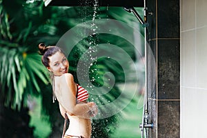 Shower On Beach. Beautiful Fit Woman Taking Shower At Swimming Pool. Girl With Body In Swimsuit Showering Under