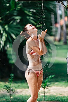 Shower On Beach. Beautiful Fit Woman Taking Shower At Swimming Pool. Girl With Body In Swimsuit Showering Under