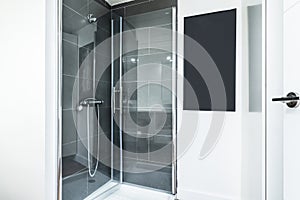 Shower cabin with glass screens in a bathroom with white walls