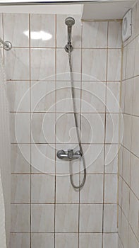 Shower in a cheap hostel or student dormitory bathroom