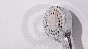 Shower head in bathroom of water droplets spraying down in bathroom. Water consumption, bill, economy, deficit and