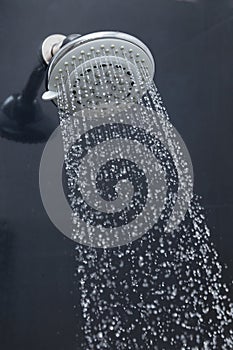 Shower head in bathroom with water drops