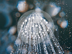 Shower head with flow of water spilling out closeup.