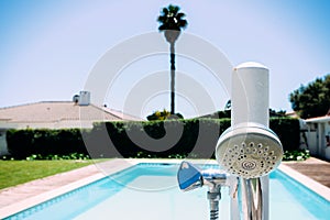 Shower head nozzle next to swimming pool with copy space