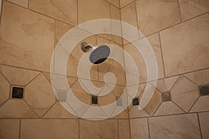 Shower head on tiled wall in bathtub area