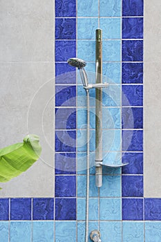 Shower head on the wall beside the pool