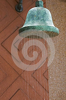 Shower head with water drops falling on a bathroom