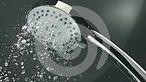 Shower head with water drops splashing out and running from faucet in bathroom flowing in slow motion