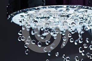 Shower Head with Water Stream on Black Background