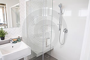 Shower room with chrome tap, transparent glass doors and a shelf. photo