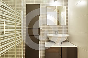 Shower room with small white chest of drawers with brown doors with square frameless mirror and matching column, porcelain sink