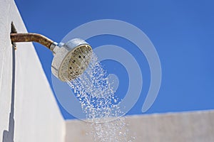 Shower with running water against the blue sky.