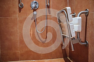Shower with seat and grab bars for disabled and elderly people in the bathroom.