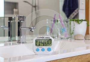 Shower timer in bathroom, used to time showers due to water restrictions caused by drought conditions through climate