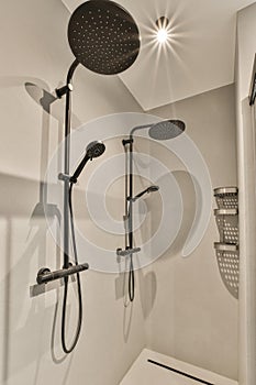 a shower with two showerheads in a white bathroom