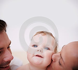 Showering her with love. Two loving young parents showing affection to their adorable baby girl.