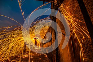 Showers of hot glowing sparks from spinning steel wool.