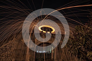 Showers of hot glowing sparks from spinning steel wool.