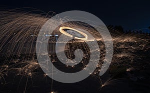 Showers of hot glowing sparks from spinning steel wool.