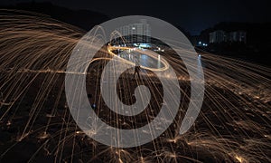 Showers of hot glowing sparks from spinning steel wool.