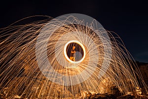 Showers of hot glowing sparks from spinning steel wool