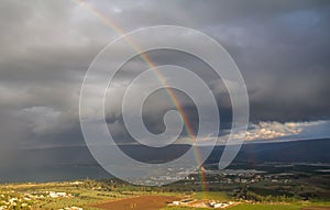 Showers and rainbow over the Sea of Galilee, Israel`s natural water sources, on a winter day with dramatic rain clouds scenery