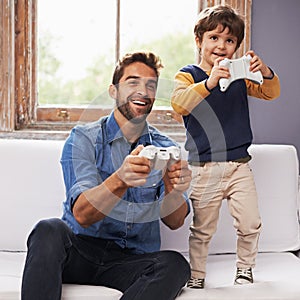 Showing Dad how its done. A handsome father and his cute son playing a video game together.